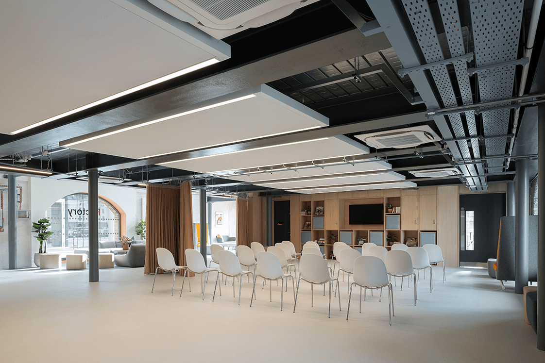 Spacious, flexible room with a presentation screen, four rows of six chairs, and an optional dividing curtain for privacy.