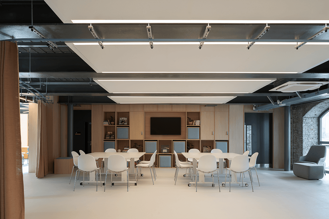 Half of the Encore event space set up with 4 movable tables and 16 chairs.